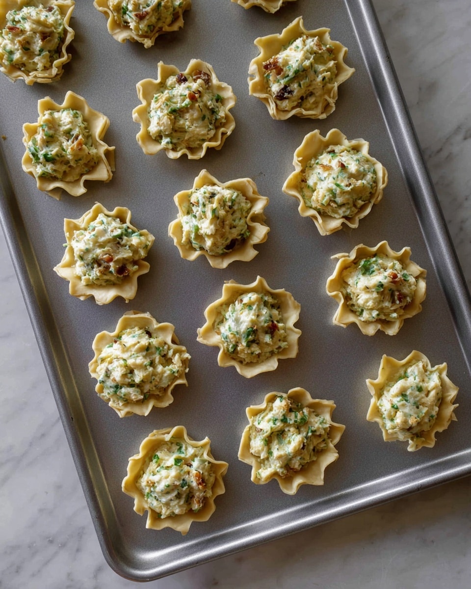 A white rectangular plate shows six mini filo shells arranged in two rows of three. The shells have a light golden brown, flaky texture with ruffled edges. Four shells are filled with different colorful toppings: one with white cream and three blueberries on top, one with dark chocolate cream and white whipped cream, one with a mix of red and white chunks with green garnish, and one with orange shredded topping and herbs. Two shells are empty, showing their cup shape and crispy layers. The plate sits on a white marbled surface. Photo taken with an iphone --ar 4:5 --v 7