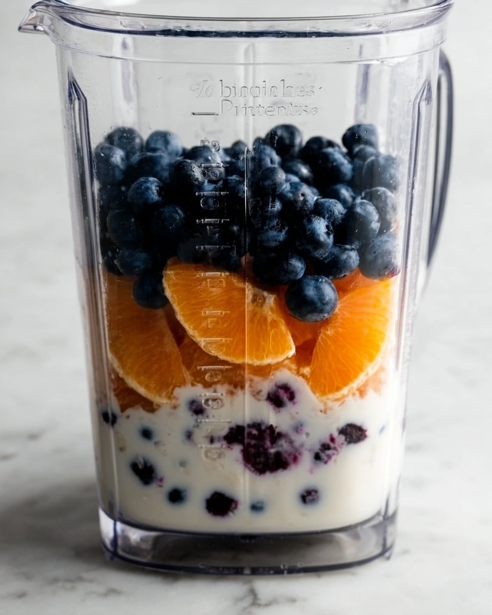 The image shows three clear glasses filled with a thick dark purple smoothie. The closest glass is in full focus, showing the smooth texture of the drink. Behind it are two more glasses with the same smoothie, slightly out of focus. To the left of the glasses, there is a yellow banana and two bright orange fruits resting on a white marbled surface. The background is softly blurred, giving a warm and cozy atmosphere. The photo taken with an iphone --ar 4:5 --v 7