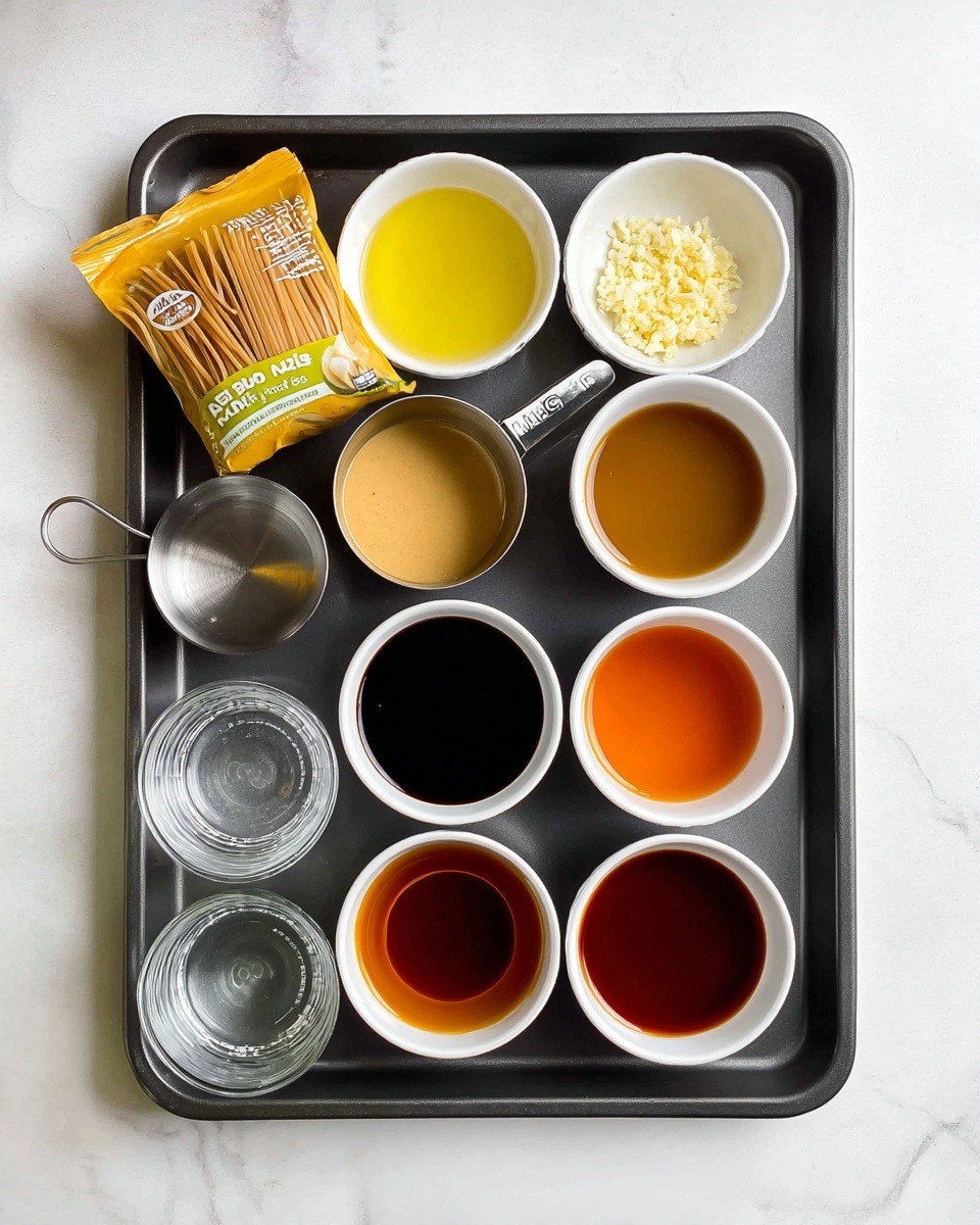 The image shows a dark gray baking tray on a white marbled surface with a yellow bag of brown Pad Thai rice noodles placed on the left side. Eight small white bowls and one metal measuring cup filled with different ingredients are neatly arranged on the tray. The top row has three bowls: one with minced light yellow garlic, one with bright yellow oil, and the metal cup contains a creamy light brown sauce. Below them are a clear glass of water, a bowl with a white liquid, and a bowl with dark soy sauce. The bottom row has three bowls holding amber-colored liquid, reddish sauce, and medium brown liquid. The setup is clean and organized, ready for cooking photo taken with an iphone --ar 4:5 --v 7