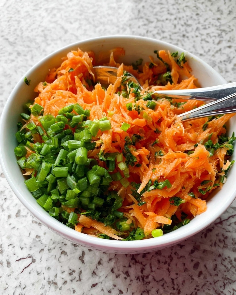 The image shows a white bowl filled with a mix of shredded orange carrots and bright green chopped scallions on top, creating two main layers with the carrots in the center and the scallions scattered around them. The bowl is set on a white marbled surface, and two silver spoons are placed inside the bowl, slightly buried in the mix. Photo taken with an iphone --ar 4:5 --v 7