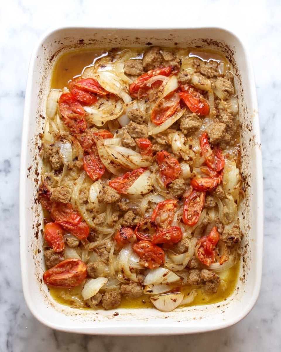 The image shows a white rectangular baking dish filled with a cooked dish that has roughly three layers. The bottom layer is a light broth or sauce. The second layer consists of cooked onions that are soft and slightly translucent with a yellow tint. The top layer is mostly made up of browned, cooked pieces of meat mixed with slices of cooked tomatoes that are soft and red. The edges of the dish have some browned bits from cooking. The baking dish is placed on a white marbled surface. photo taken with an iphone --ar 4:5 --v 7