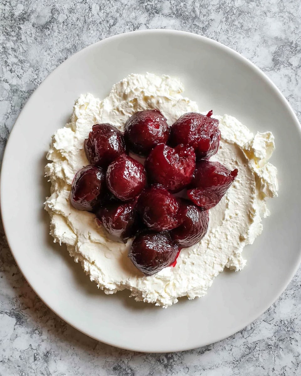 A white bowl with a patterned inner surface holds two large, soft, and creamy white scoops of thick yogurt or cream, with some shiny pools of golden honey drizzled on top giving a slight yellow tint in spots; the texture looks smooth and fluffy with gentle folds and peaks. The bowl sits on a white marbled surface. Photo taken with an iphone --ar 4:5 --v 7