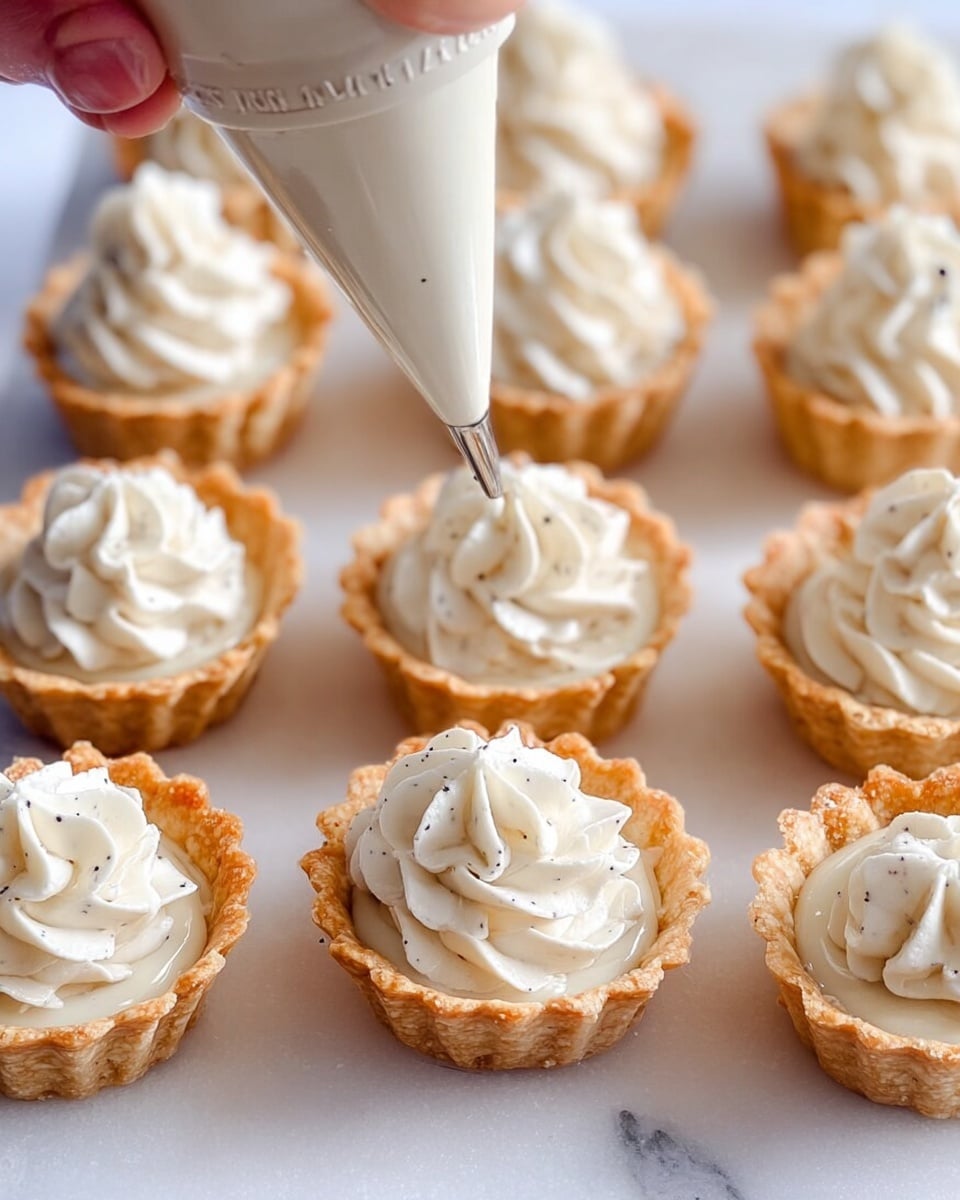 The image shows a close-up of small tart shells arranged on a white marbled surface. There are three columns of tart shells, with the two outer columns filled with light golden-brown crispy crusts and the middle column being filled with smooth, creamy white whipped filling that has small black vanilla specks. A piping bag held by a woman's hand is in the act of adding the swirled whipped cream on top of one tart shell in the middle row. The filling is piled in a neat swirl, creating texture and height in each tart. The color contrast is between the golden crusts and the soft white cream, with the background and tray all having a clean white marbled look. photo taken with an iphone --ar 4:5 --v 7