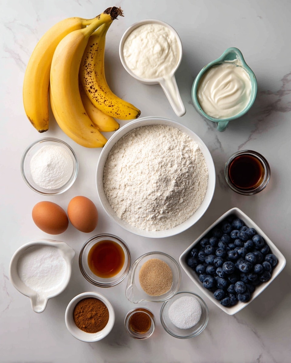 The image shows an overhead view of various ingredients placed on a white marbled surface. In the center, there is a white bowl filled with white flour. Around it, starting from the top left, there are three ripe yellow bananas with brown spots, a small white measuring cup with white yogurt, a small green cup, a square white bowl full of fresh blueberries, and three small glass bowls containing white salt, baking powder, and baking soda. At the bottom left, there is a white egg holder with two brown eggs, next to it a small round bowl with light brown sugar, and a small white bowl with dark amber vanilla extract. Nearby is a small white bowl with a mix of cinnamon and other spices. The items are neatly arranged with a clean and simple look. photo taken with an iphone --ar 4:5 --v 7