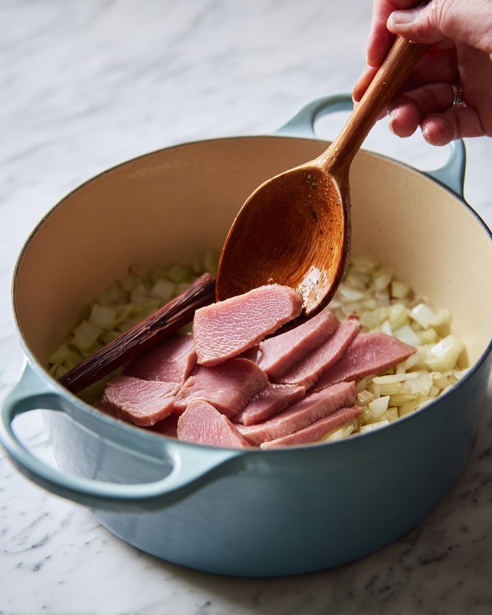A dark bowl filled with a base layer of white rice. On top, there is a thick yellow curry sauce covering pieces of light-colored chicken and green broccoli florets. Over the curry, there are crispy fried shallots and fresh cilantro leaves scattered as garnish. The bowl sits on a white marbled surface with a light fabric nearby. photo taken with an iphone --ar 4:5 --v 7