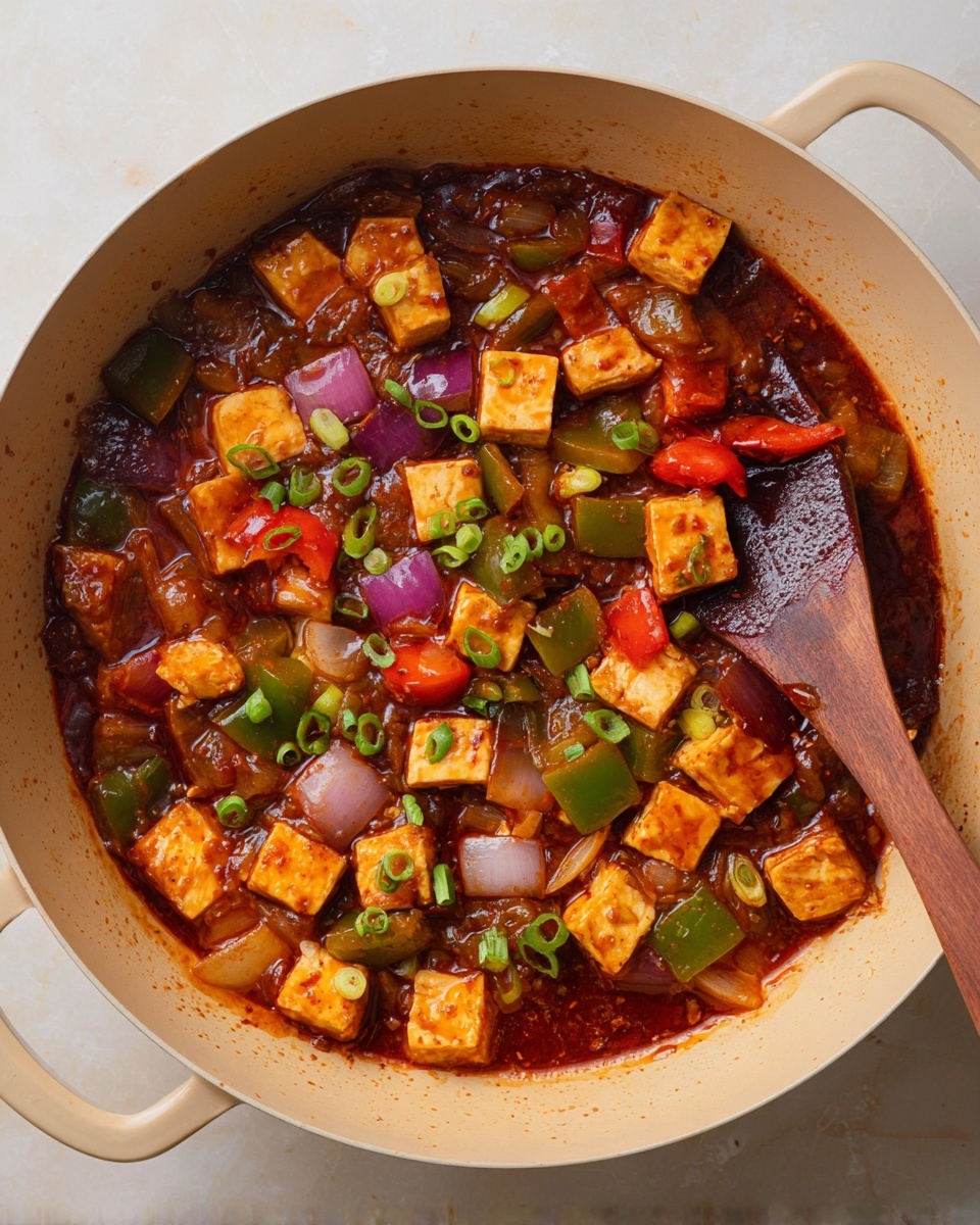 A white plate holds a dish with a mound of light brown rice in the center, surrounded by a thick reddish-brown sauce filled with bright orange cubes, possibly tofu, and chunks of red onion and vegetables. The sauce is garnished with chopped green onions scattered on top. A gold fork rests on the left side of the plate. In the top right corner, part of another white plate with a mix of light brown rice and vegetables is visible. The setting is on a white marbled textured surface with some green onion stalks nearby. Photo taken with an iphone --ar 4:5 --v 7