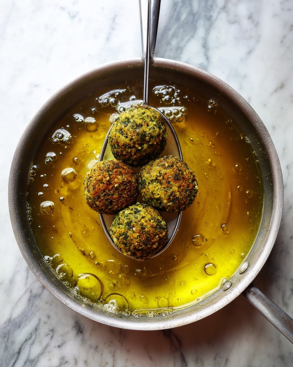 A clear round food processor bowl filled with finely chopped green and yellow mixture that looks like herbs and nuts mixed together, covering the entire inner surface with a slightly rough texture. In the center, there is a white blade attachment sitting low in the bowl. The background is a white marbled texture with soft lighting and soft shadow on the right side. photo taken with an iphone --ar 4:5 --v 7