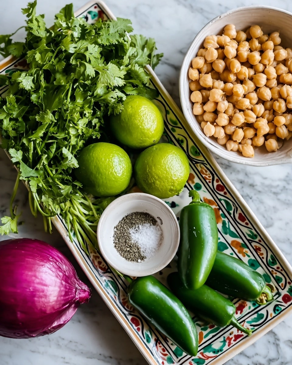 A white bowl filled with a single layer of light yellow chickpeas with a smooth and round texture sits on a white marbled surface. Next to it, there is a long dark green cucumber placed horizontally. To the right of the cucumber, three red tomatoes with a shiny surface lie close to each other. On the left side of the cucumber, two dark, rough-skinned avocados rest near a red onion with a smooth purplish outer layer. Above these, a rectangular white dish holds four bright green limes, a bunch of fresh green cilantro leaves, three small dark green peppers, and a small white bowl containing white salt and black pepper side by side. photo taken with an iphone --ar 4:5 --v 7