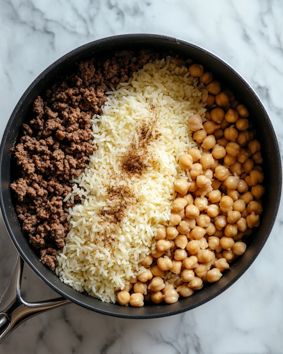 A close-up top view of a black pot filled with one layer of cooked ground beef mixed with small pieces of cooked onions. The beef is brown with a coarse texture, and the onions are soft and translucent, scattered evenly throughout. The pot sits on a white marbled surface. Photo taken with an iphone --ar 4:5 --v 7