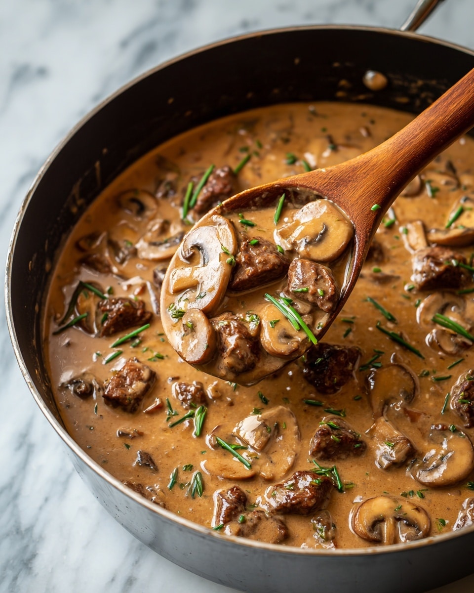 In a white pot with two side handles, there are many cooked brown mushrooms spread evenly at the bottom. On top, a light beige powder is being added in the center, creating a soft mound that contrasts with the darker mushrooms below. A woman's hand is holding a wooden spoon, stirring the mixture, with the spoon partially covered by the powder. The pot sits on a white marbled surface, and the overall scene has a warm, cozy feeling. photo taken with an iphone --ar 4:5 --v 7
