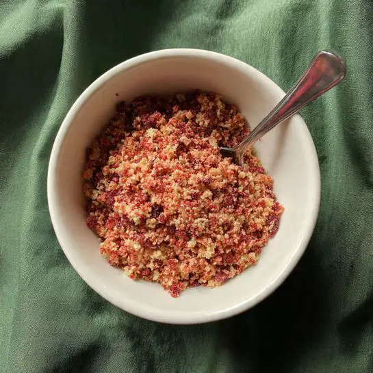The image shows a thick layer of white, creamy frosting smoothly spread inside a dark gray rectangular baking pan. The frosting has soft swirls and slight peaks on its surface, giving it a textured look. The pan sits on a white marbled surface. Photo taken with an iphone --ar 4:5 --v 7