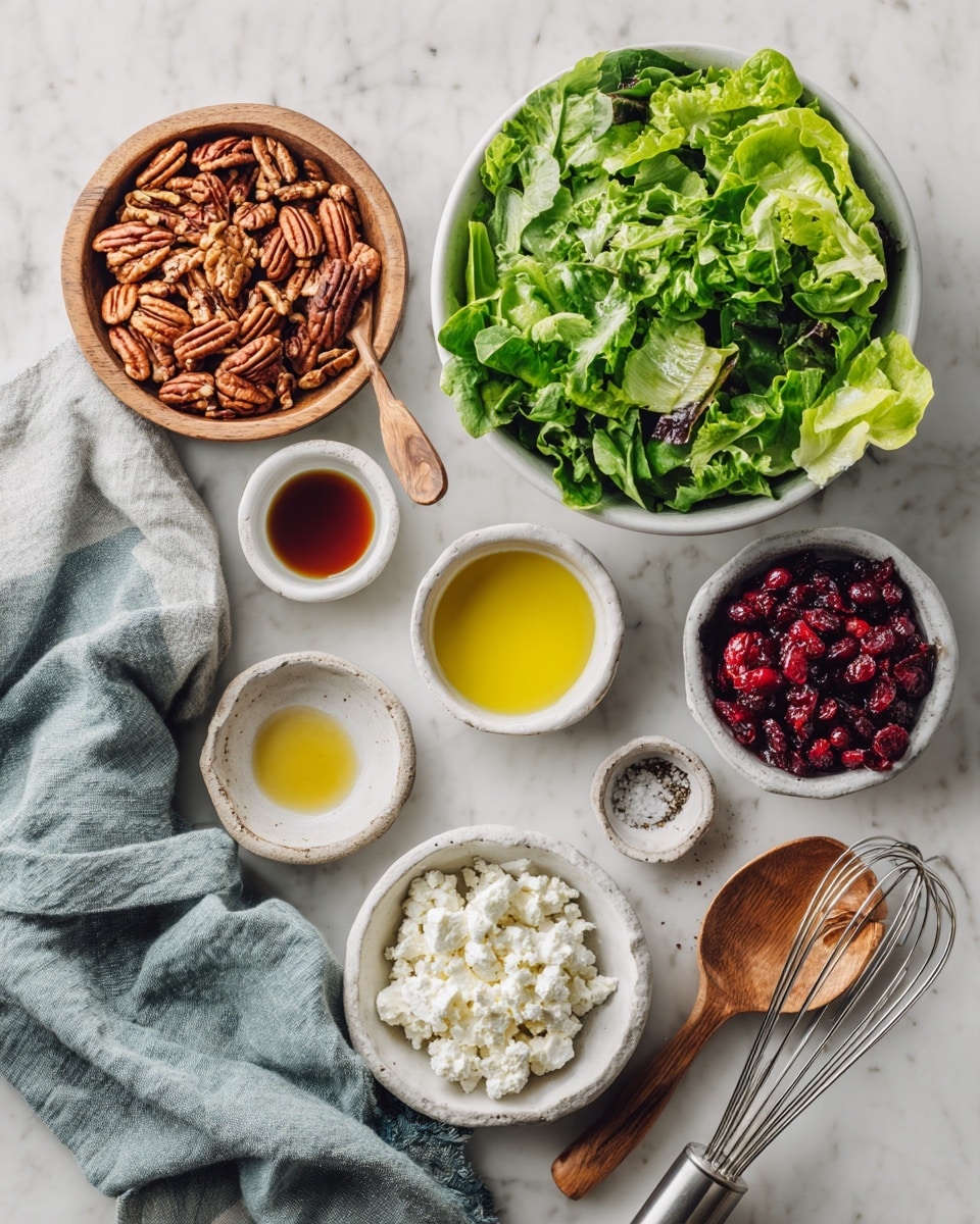 A fresh salad served in a white bowl with a thin peach rim, filled with mixed leafy greens including dark purple and bright green leaves. The salad is topped with small white crumbles of cheese, scattered dried red berries, and roughly chopped light brown pecans. Two silver forks rest on the edge of the bowl. In the background, there is a clear glass bowl with more dried red berries and a white bowl with additional pecans, all set on a white marbled surface with a white cloth nearby. photo taken with an iphone --ar 4:5 --v 7