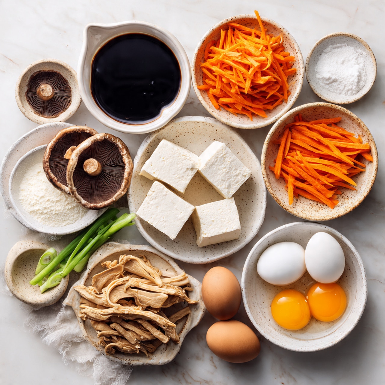 A white bowl filled with a thick brown soup that shows pieces of tofu, orange carrot strips, green leafy vegetables, and brown mushroom slices mixed inside. A white ceramic spoon rests in the bowl, lifting a spoonful of the soup, revealing the varied textures and colors, with the tofu and vegetables clearly visible. The bowl is placed on a white marbled surface with a glass of dark liquid and a white bowl blurred in the soft background. Photo taken with an iphone --ar 4:5 --v 7