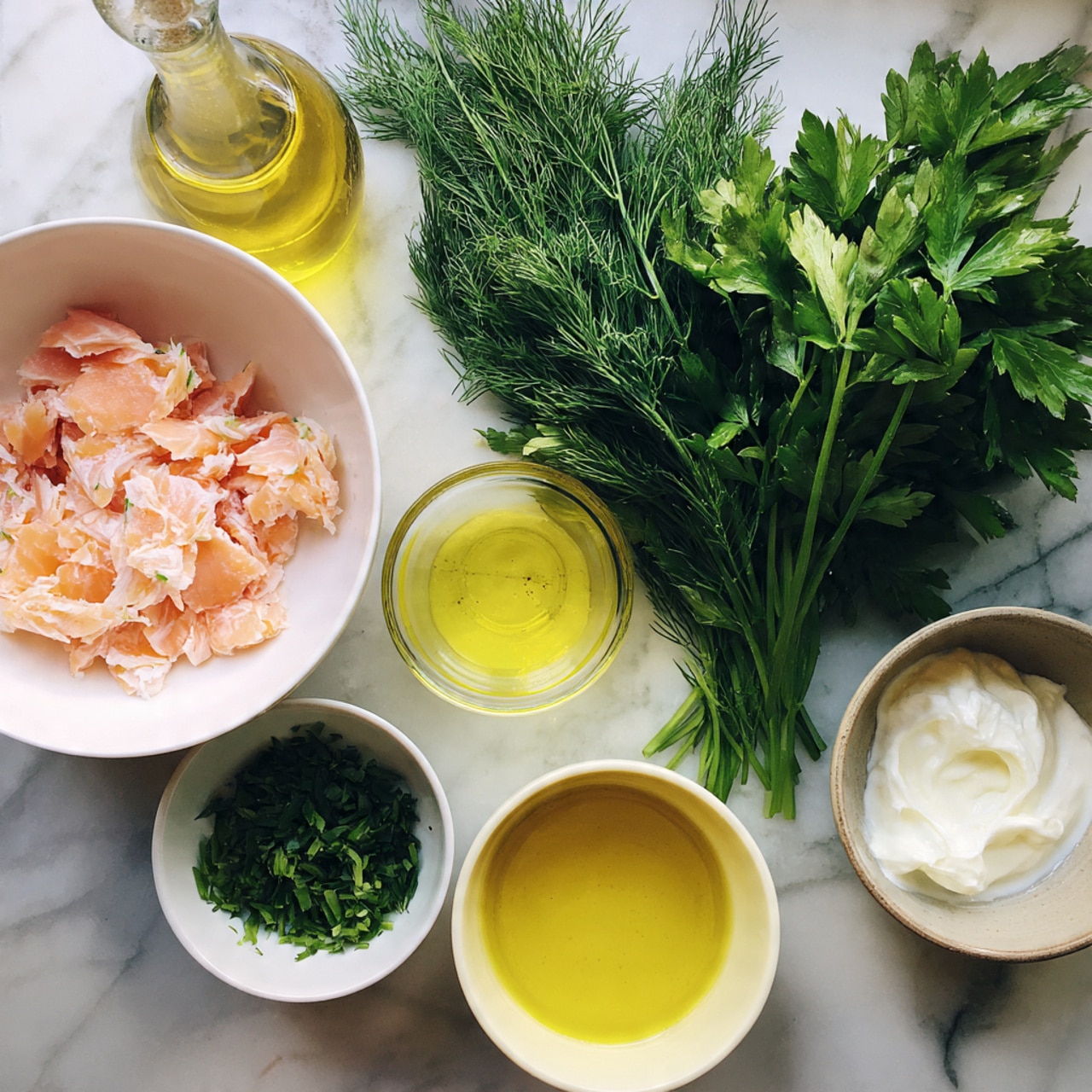 A white plate on a white marbled surface holds a cooked salmon fillet that is pink-orange with herbs sprinkled on top. The salmon is topped with a thick, creamy white sauce that has small green herb bits mixed inside. Around the salmon, there is a pile of roasted small round potatoes that are golden brown with green herb flecks. A small lemon wedge and fresh green dill sprigs sit on the plate’s left side. A fork rests on the white marbled surface next to the plate. photo taken with an iphone --ar 4:5 --v 7