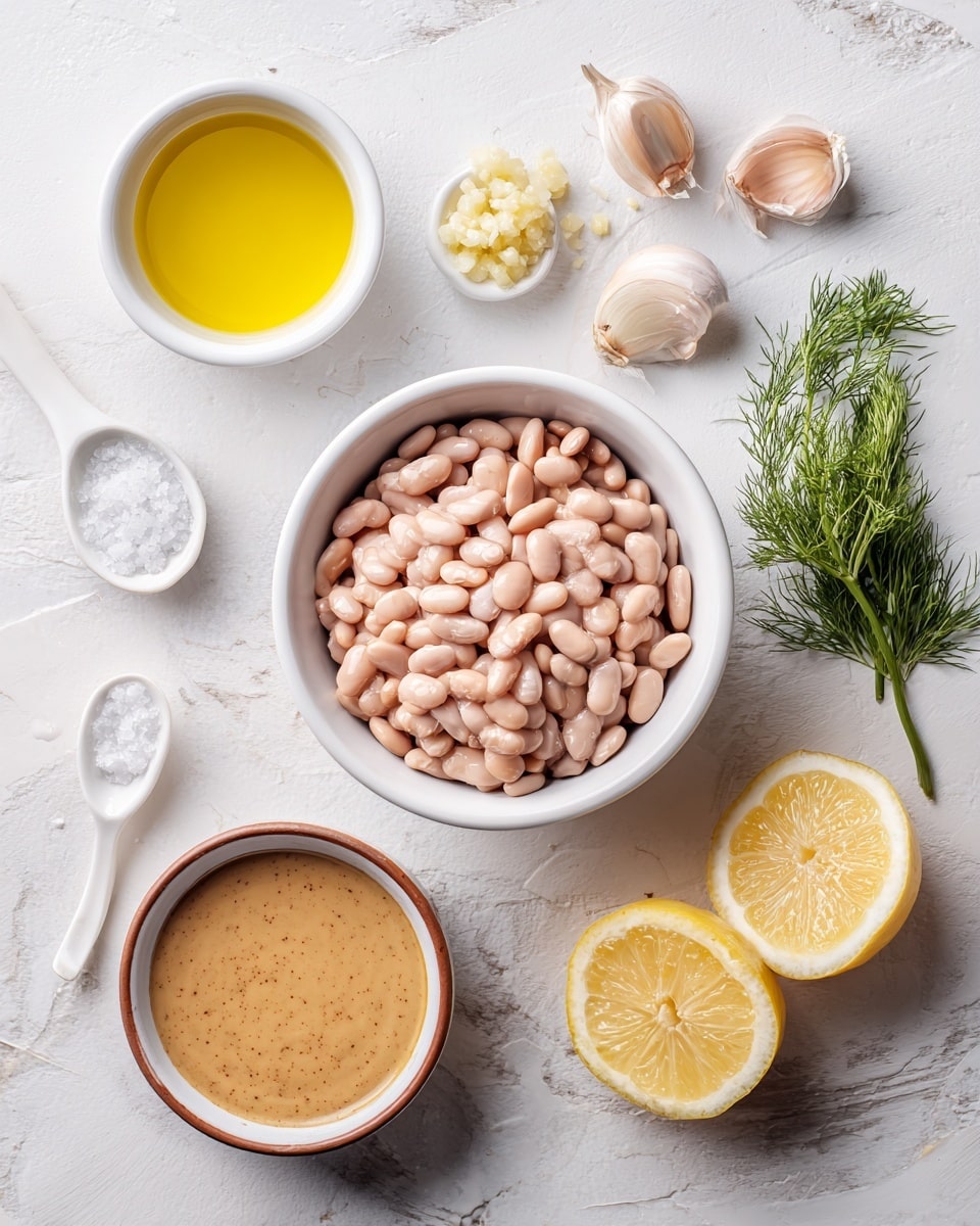 A white bowl filled with light pink beans sits at the center on a white marbled texture. To its left, a white spoon holds crushed garlic, next to a white spoon filled with coarse salt. Above the bowl, there is a small white bowl filled with golden yellow liquid, likely oil. On the right side, there are three lemon slices stacked beside five peeled garlic cloves and a small bunch of green dill. Below the lemon slices, a white bowl with a brown rim contains a smooth, beige-colored sauce. The photo is taken with an iphone --ar 4:5 --v 7
