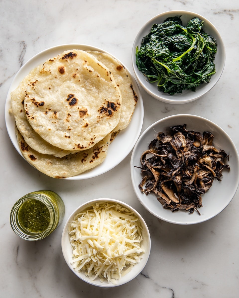 The image shows four white dishes on a white marbled surface. One plate holds three slightly browned tortillas stacked on top of each other with some dark spots. Another plate contains cooked dark green spinach leaves loosely piled. A third bowl is filled with dark brown cooked sliced mushrooms, showing a glossy texture. The last small bowl has a mix of shredded white and yellow cheese, heaped to the top. A small glass jar with green sauce sits next to the bowls. Photo taken with an iphone --ar 4:5 --v 7