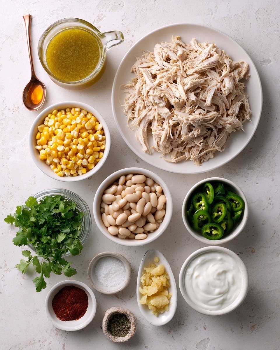 A white bowl filled with creamy soup showing chunks of shredded chicken mixed with yellow corn and small green herbs throughout. On the surface, there are three slices of bright green avocado on one side, a sprinkle of shredded white and orange cheese scattered evenly, and some chopped green onions. A silver spoon with a decorative handle rests inside the bowl, and near the bowl on the white marbled surface, there are fresh lime wedges and a small sprig of green cilantro. The soup has a rich, slightly thick texture with visible bits of spice and herbs mixed in. photo taken with an iphone --ar 4:5 --v 7
