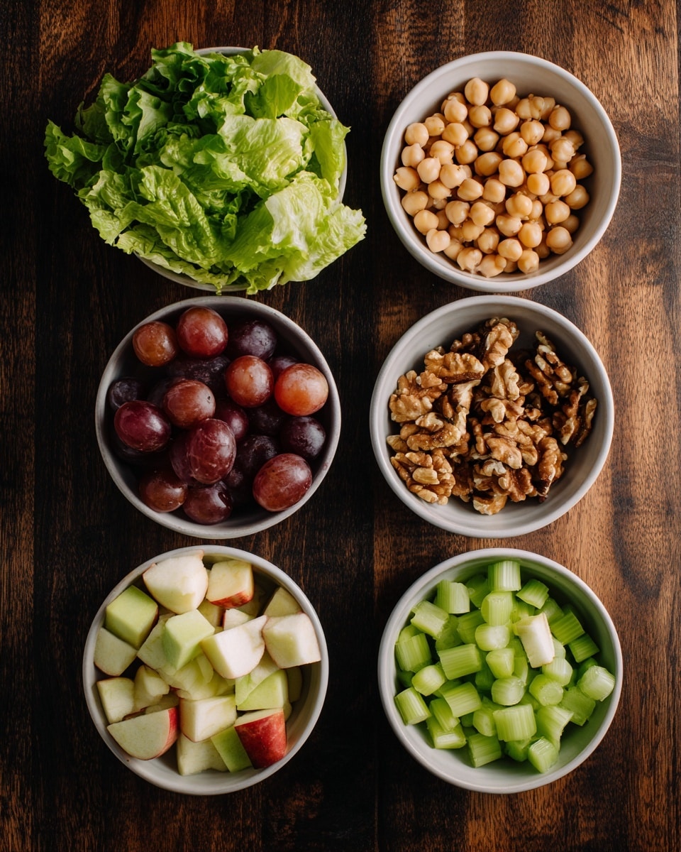 Six round white bowls sit on a dark wooden surface. The top left bowl holds bright green leafy lettuce with a soft texture. On the top right, a bowl is filled with light beige chickpeas, smooth and round. Below that, the medium bowl contains light to medium brown walnut pieces with a rough texture. To the left of the walnuts, a bowl has many sliced dark red grapes with shiny skins. Below the grapes, a bowl is filled with small cube-shaped pieces of apple showing their cream and red skins. Finally, the bottom right bowl has chopped green celery with a firm, crisp look. photo taken with an iphone --ar 4:5 --v 7