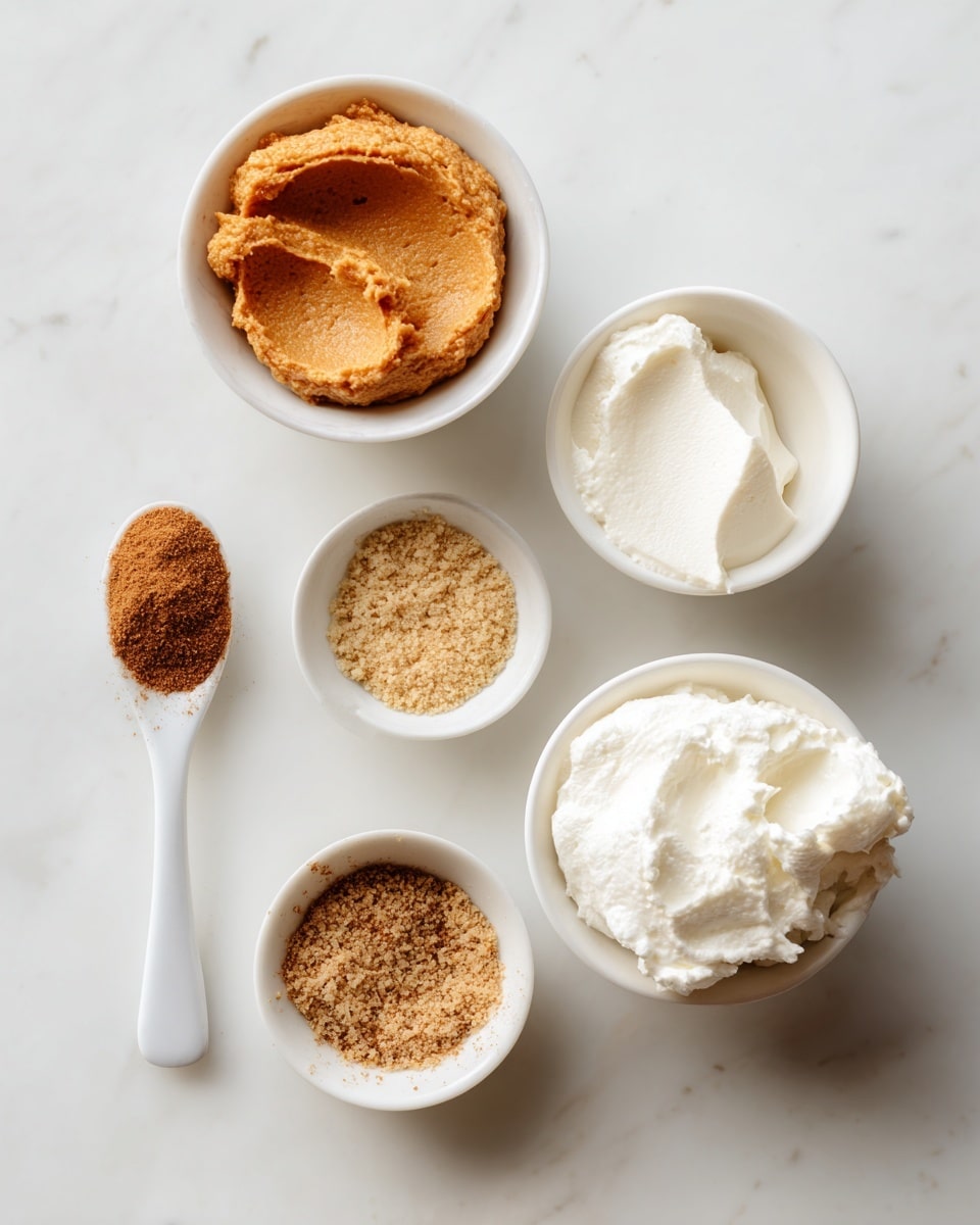 A top-down view of a silver metal mixing bowl filled with smooth light brown batter. The batter has a creamy texture and lightly covers the sides of the bowl, with some batter streaks around the edges. The bowl sits on a white marbled surface, adding a clean and bright background to the image. photo taken with an iphone --ar 4:5 --v 7