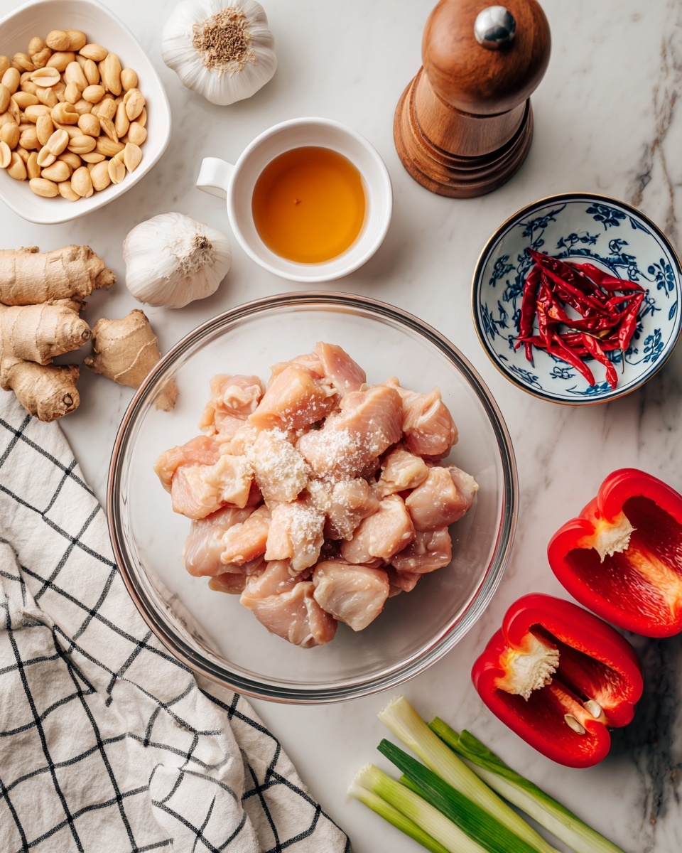 A clear glass bowl is filled with raw, light pink chicken pieces covered in a soy sauce mixture with some white powder on top, placed in the center on a white marbled surface. To the top left, a white dish holds light brown peanuts, next to a small white bowl with amber-colored liquid, and a wooden pepper grinder. To the top right, a small round blue bowl with white floral patterns contains a whole garlic bulb and several red dried chili peppers. Fresh light brown ginger root pieces and green onion stalks lie nearby on the right. At the bottom right, two halves of a bright red bell pepper show their white inner ribs and seeds. A white tea towel with a black grid pattern is partly visible at the lower left. photo taken with an iphone --ar 4:5 --v 7