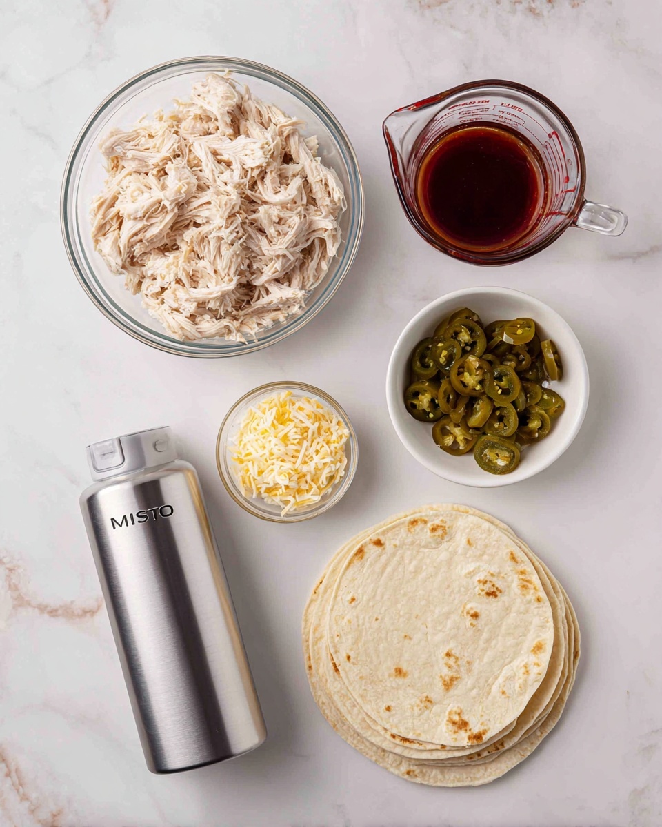 The image shows five items on a white marbled surface arranged neatly: a clear glass bowl filled with shredded light beige cooked chicken at the top left, a measuring glass jug containing a dark red sauce at the top right, a small white bowl holding green chopped pickled jalapeños near the center left, a clear glass bowl with a mix of shredded yellow and white cheese at the bottom left, and a stack of round, light beige tortillas on the right side near the bottom, slightly overlapping each other. A silver spray bottle labeled