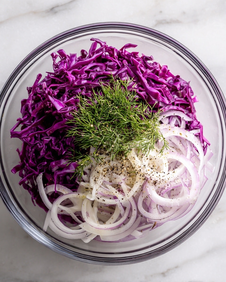 A clear glass bowl filled with finely shredded purple cabbage forming the first layer, topped with a large pile of thinly sliced light purple onions scattered evenly, and a small bunch of fresh green dill placed slightly off center. The onions have a light sprinkling of black pepper over them. All layers contrast vividly in color, giving a fresh and crisp look against a white marbled surface. Photo taken with an iphone --ar 4:5 --v 7