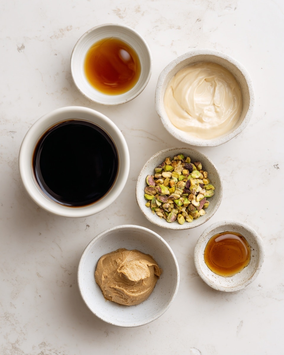 The image shows six small white bowls and cups placed on a white marbled surface. Starting from the top left, there is a small white bowl with a dark amber liquid, next to it is a larger white bowl filled with a light cream-colored liquid. Below these, on the left, there is a white cup filled with a very dark, almost black liquid. To the right of this cup, there is a small white bowl containing a mix of crushed nuts, mostly green with some yellow and brown bits. Below that on the left, there is a white bowl with a scoop of light brown soft paste. Finally, at the bottom right, another small white bowl holds a small amount of a shiny amber liquid. photo taken with an iphone --ar 4:5 --v 7