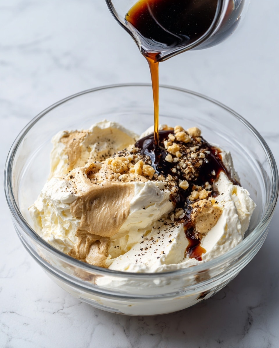 A clear glass bowl sits on a white marbled surface, filled with several layers of ingredients. At the bottom, there are thick, creamy white dollops of mayonnaise and sour cream that have a smooth texture. On top and mixed in lightly are dark brown thick paste spots, a light beige creamy dollop, and tiny bits of minced garlic with a rough, moist texture. A dark liquid, likely soy sauce or similar, is being poured from a small container into the bowl, creating a glossy, flowing layer over the other ingredients. Black pepper is sprinkled across everything, adding small dark specks. Photo taken with an iphone --ar 4:5 --v 7