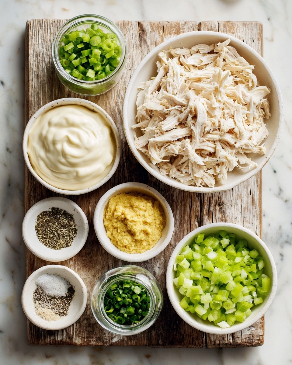 A bird's-eye view of a rustic wooden board on a white marbled surface, holding seven small white bowls and a small glass jar, each filled with different ingredients. At the top right, a large white bowl is filled with shredded cooked chicken that is light beige with golden brown edges. Below it, to the left, is a medium white bowl filled with creamy white mayonnaise. To the right of the mayo, a medium white bowl holds light green chopped celery pieces. Next to these, smaller white bowls contain mustard (yellow), dried green herbs, ground black pepper, and ground white pepper, arranged neatly in a curved line. The small glass jar at the bottom left holds chopped green onions. The overall setup is neat and clear, emphasizing the fresh ingredients, photo taken with an iphone --ar 4:5 --v 7