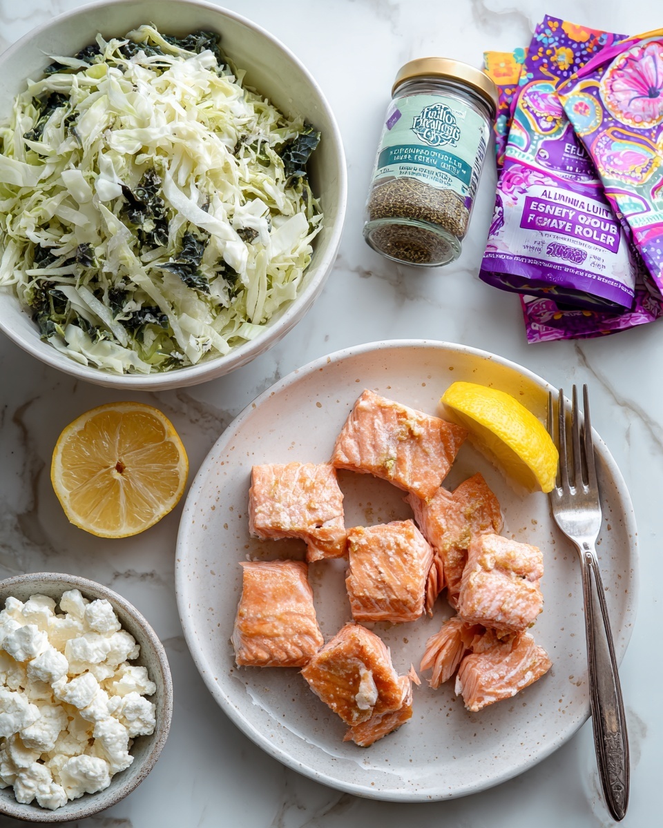 The image shows a white plate with several pieces of cooked, flaky salmon in shades of pink and orange with visible texture, a silver fork resting on the plate among the fish pieces, next to a lemon wedge. To the left is a white bowl filled with shredded green cabbage. Below the plate is a white bowl holding crumbly white cheese with a silver spoon inside. A small jar labeled 
