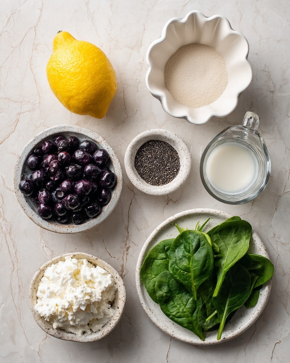 The image shows seven items arranged on a white marbled surface: at the top left, half a lemon with a bright yellow color; next to it, a white scalloped bowl filled with beige powdered substance; to the right, a clear measuring cup with white liquid inside; below that, a small white scalloped bowl with dark chia seeds; in the center left, a white speckled plate filled with dark purple blueberries; below, a smaller white bowl with white cottage cheese that has a textured, lumpy surface; and finally at the bottom right, a white speckled plate with fresh green spinach leaves, smooth and vibrant. Photo taken with an iphone --ar 4:5 --v 7