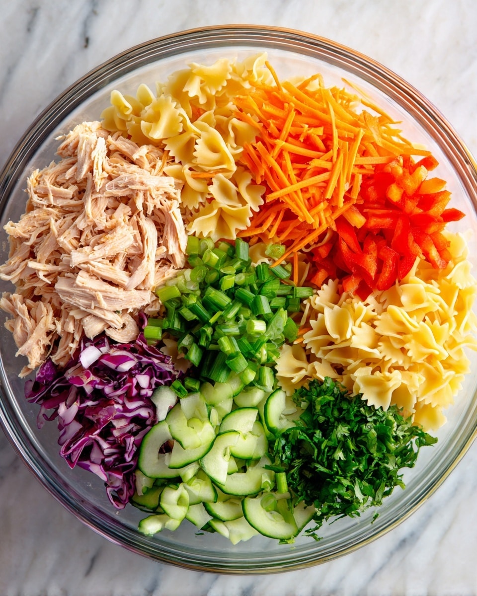 A top view of a clear glass bowl with seven fresh layers arranged in a circle on a white marbled surface. Starting from the top left, there is a layer of shredded light pink chicken, next to it shredded orange carrots, then pale yellow farfalle pasta, followed by red bell pepper strips. Below that, thinly sliced green scallions sit beside shredded dark purple cabbage, then sliced cucumber rounds, and finally chopped green cilantro fills the last section. The layers are colorful and fresh, evenly placed in the bowl. Photo taken with an iphone --ar 4:5 --v 7