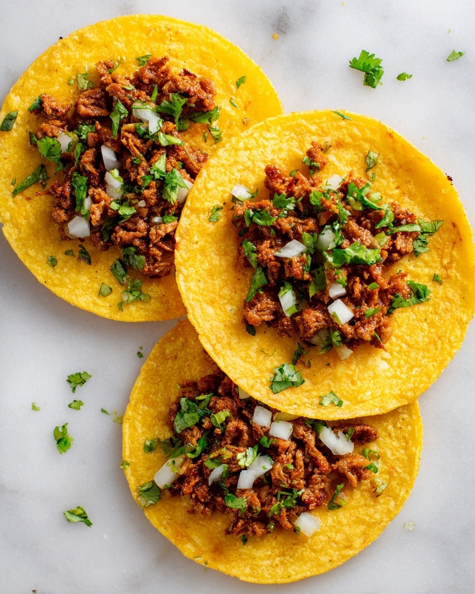 The image shows three yellow corn tortillas placed separately on a white marbled surface. Each tortilla has a middle layer of small, brown cooked meat pieces with a slightly rough texture. Scattered on top of the meat are small white onion chunks and fresh green cilantro leaves, adding small pops of white and green color. The tortillas are evenly spaced and viewed from above, showing a simple, colorful arrangement that highlights the texture and freshness of the ingredients. photo taken with an iphone --ar 4:5 --v 7