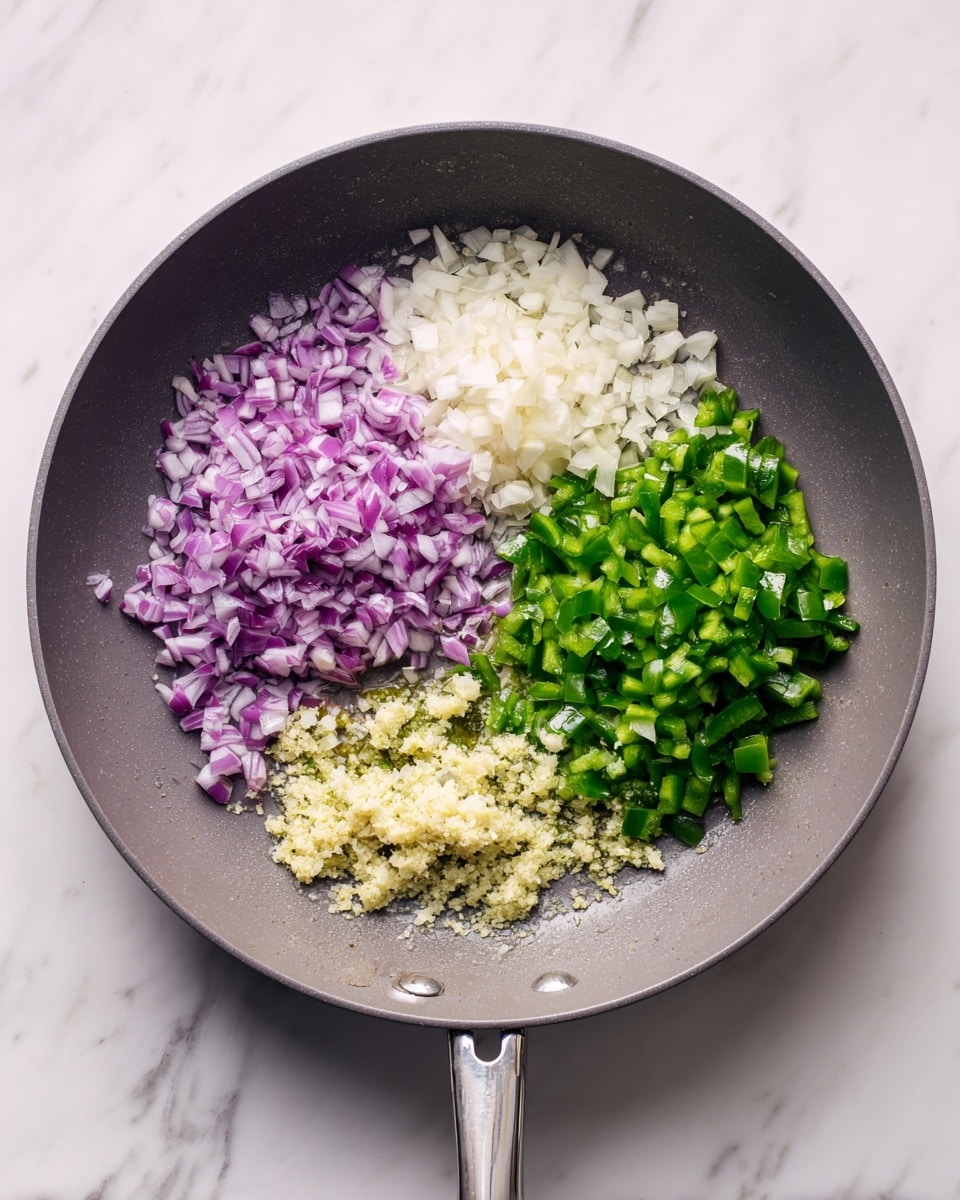 A grey frying pan sits on a white marbled surface, filled with four piles of chopped ingredients evenly spaced inside. The top left pile is finely chopped purple onion with white bits mixed in, just below it is a pile of finely chopped white onion. To the right of these onions is a bright green pile of chopped green bell pepper. On the far right of the pan there is a layer of finely minced garlic mixed with olive oil, showing a pale yellow and oily texture. The pan handle points to the upper left corner of the image. Photo taken with an iphone --ar 4:5 --v 7